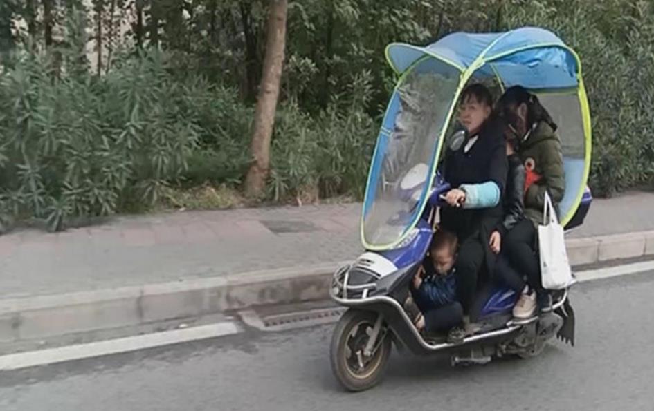 好危险！电动车载四个人两人是小孩
