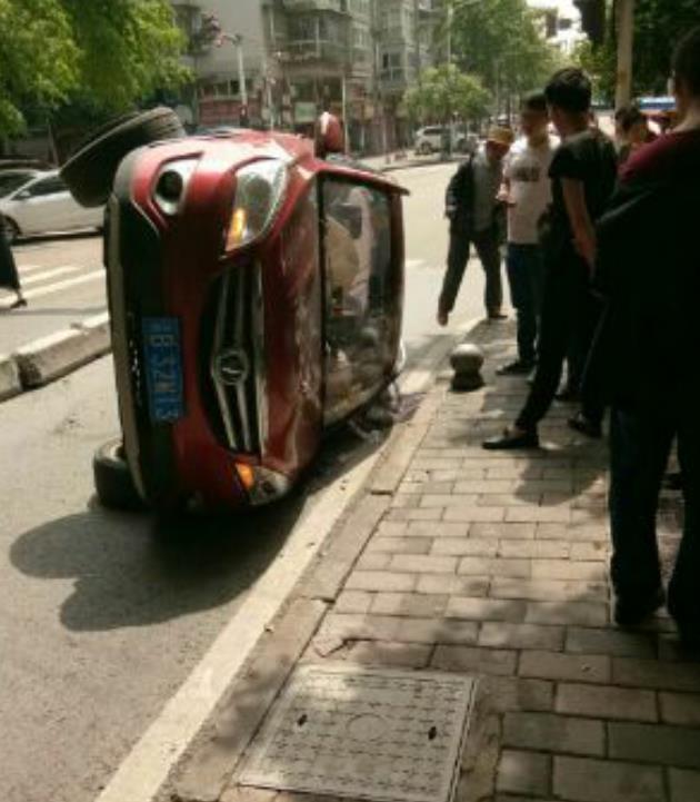 红色小车速度太快 撞上水泥隔离带后侧翻