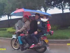 二轮摩挤上四人 男子背着的幼儿双脚悬空