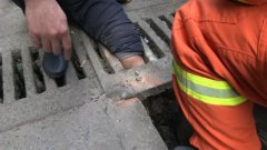 只顾埋头看手机 一脚踩空被卡住