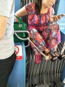 <b>女子在轻轨车厢连接处各种消遣  坐姿千变万化</b>