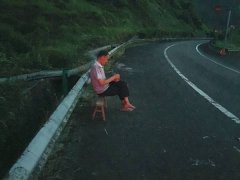 男子拎根板凳手拿茶杯翘着二郎腿 高速路上乘凉