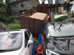 货车爬坡后溜撞倒围墙 墙边轿车跟着遭殃