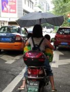 心真大！女司机抱着两小孩骑电动车 雨中狂奔