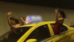 三女子将出租车当敞篷跑车 悬坐在车窗上
