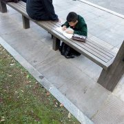 小学生趴在公交站台写作业  网友称赞＂国之栋梁＂