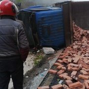大货车刹车失灵侧翻路边   红砖倾洒一地