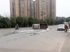 长安车侧翻横停路中央 建材散落一地
