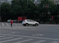 红灯还亮着 她捧着手机低头走到了公路中间