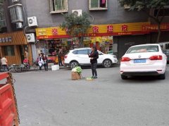 险！女子马路中间卖菜 旁边就是呼啸而过的汽车