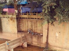 高手所为？两辆共享单车悬在河边堤坝上