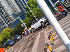 尴尬！轿车“骑”在隔离拦上下不来