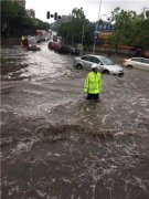 暴雨致街头积水 执勤辅警冒雨站水中当路标