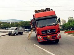 车辆满载货物上路 却在转盘里“杵拐”