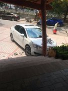 小轿车撞上路边店铺门头  引擎盖上全是砖头瓦片