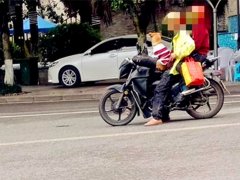 摩托车上一狗两人 乍一看以为是“狗载人”