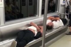 两男子车厢内竖躺着睡觉  其他乘客却站着