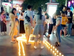 女子穿白纱向男子求婚 步行街头引围观