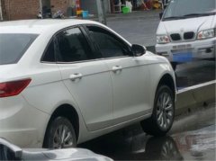 重庆街头现“神停车”  车轮悬空“骑”上隔离带