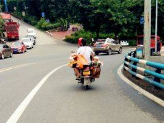 女子拎行李带娃坐摩托 造型开挂画风惊悚