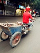 男子驾摩托绑上手推车 淡定在路上行驶