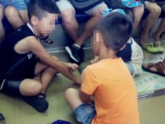 3名男童围圈坐在车厢通道处  玩起了游戏