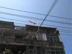 皮带缠在电线上垂直于地面 过往路人很担忧