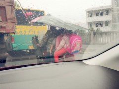 男子骑摩托载3个娃上路 后排女孩背着书包悬坐着