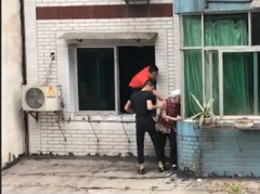 老太站在五楼窗台的雨棚上 情况危急
