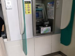 一对男女ATM机上取钱 却随手将牛奶放在另外一边