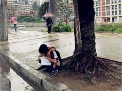小男孩躲在大树下写作业  网友：没带伞？