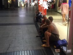 几位大爷并排坐 疑似蹭空调“挡”在他人店门口